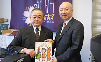 櫻井補習授業校校長に冊子を寄贈する同所所長（右）