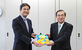「童話の花束」を寄贈する同所総務ＧM（左）と 成田川崎市 市民・こども本部長（同時）（右）
