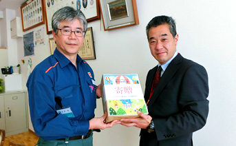 「童話の花束」を寄贈する同所長（左）と本牧南小学校副校長