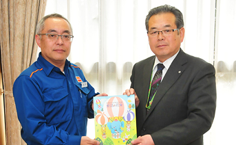 相川町長（写真右）に寄贈する同社社長（写真左）