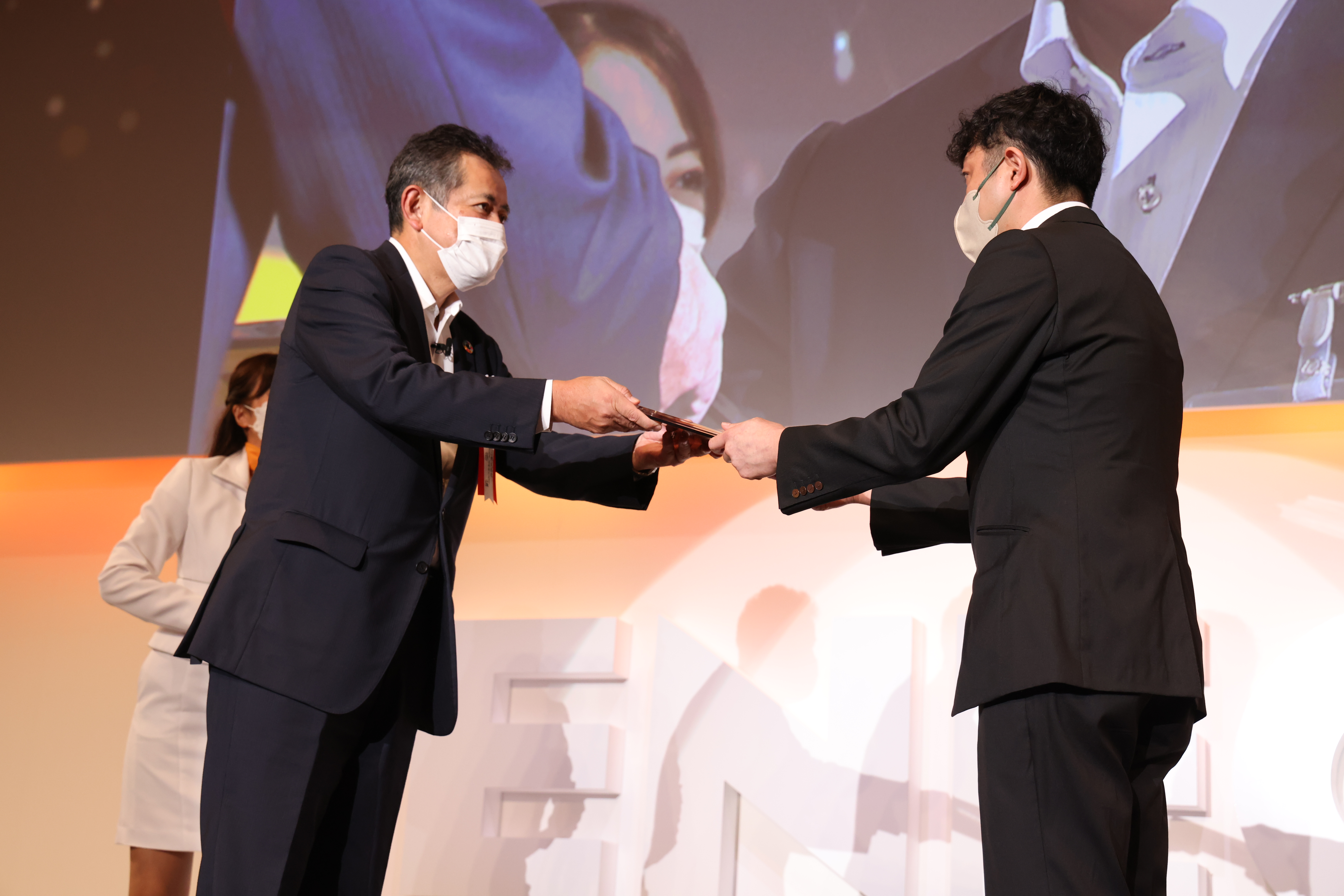 左：受賞者に表彰盾を贈呈する当社社長 齊藤　猛