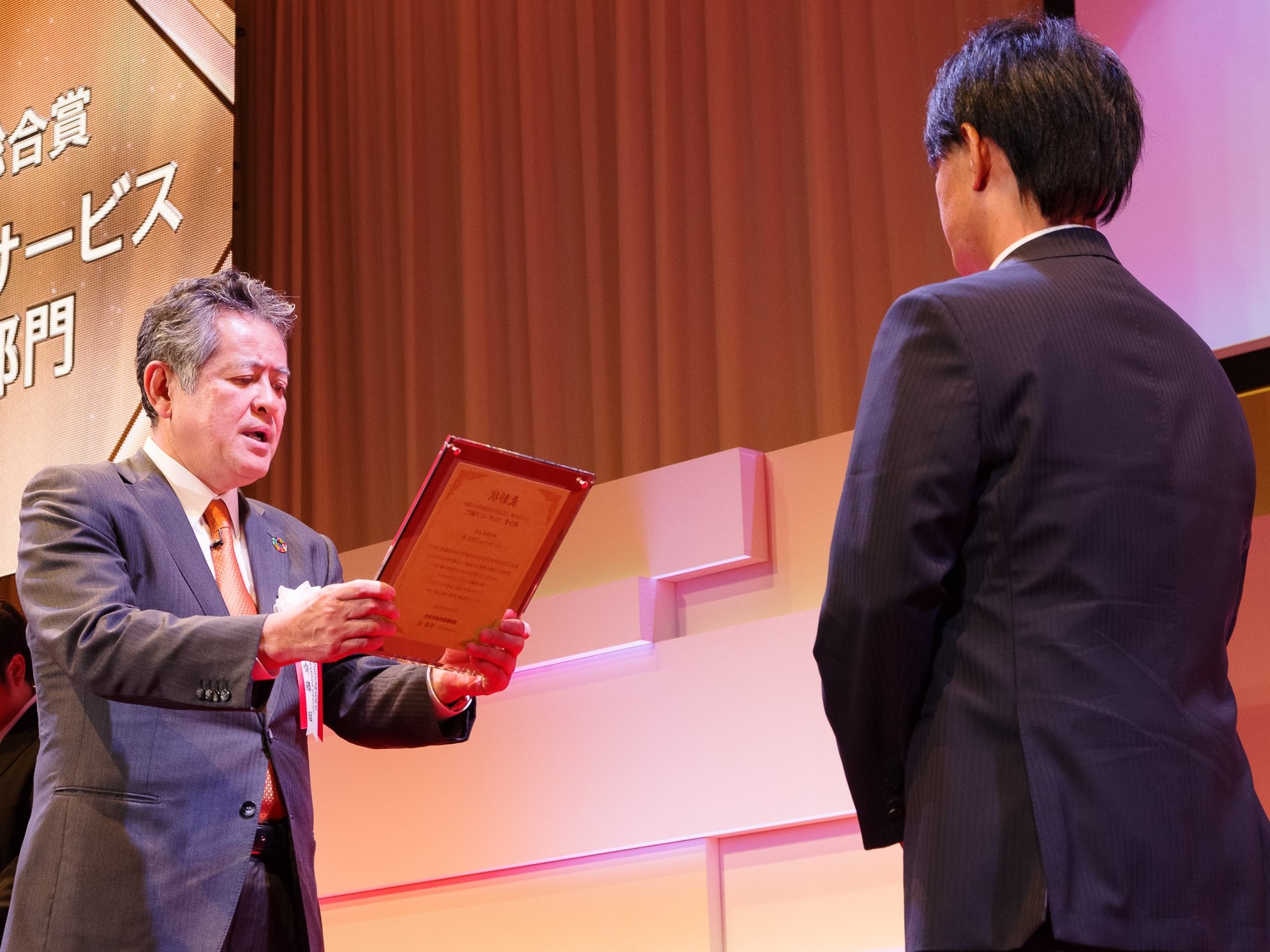 左：受賞者に表彰盾を贈呈する当社社長 齊藤　猛