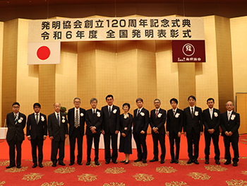 表彰式での記念撮影。左から5人目が横国大・梅原学長、8人目が藤山常務、9人目がデノラ社・大倉社長